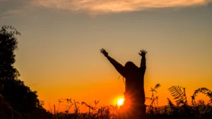 woman praying facing the bright sun to eliminate fear